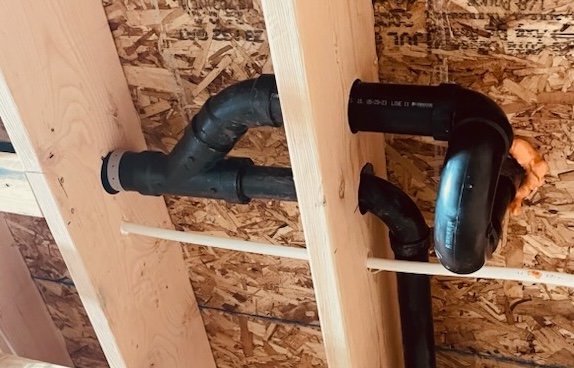 Hole in a joist with a pipe running through it.