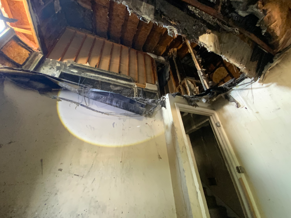 Floor showing hole and structural damage from fire.