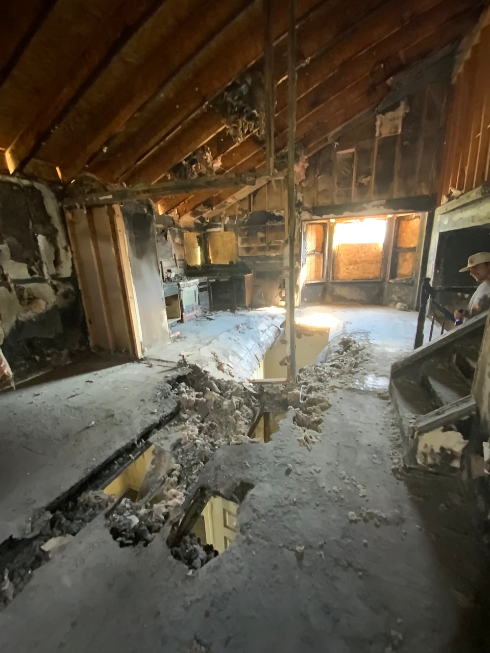 Floor showing hole and structural damage from fire.