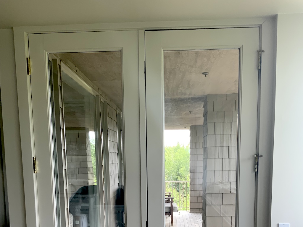 Double doors showing uneven gaps and signs of foundation settlement.