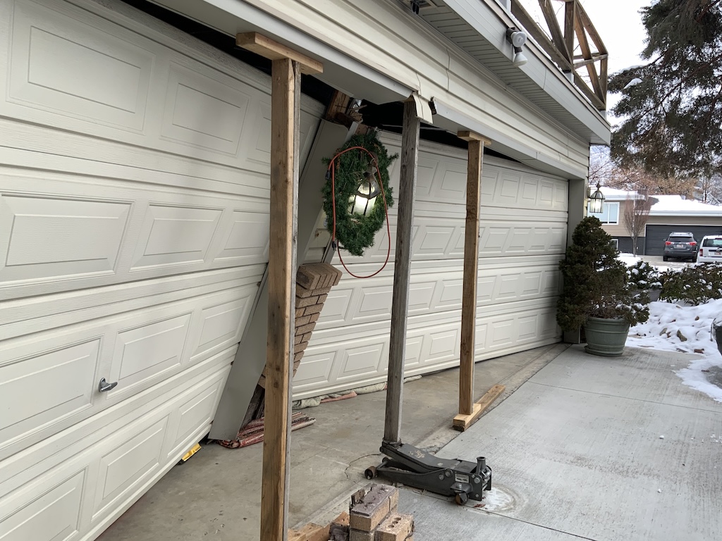 Example of accidental damage to structure. Garage door which has been knocked inwards. 