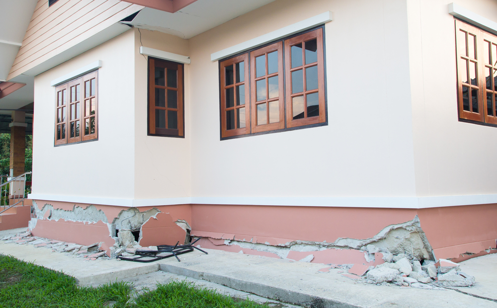 House showing cracks and earthquake damage around foundation.