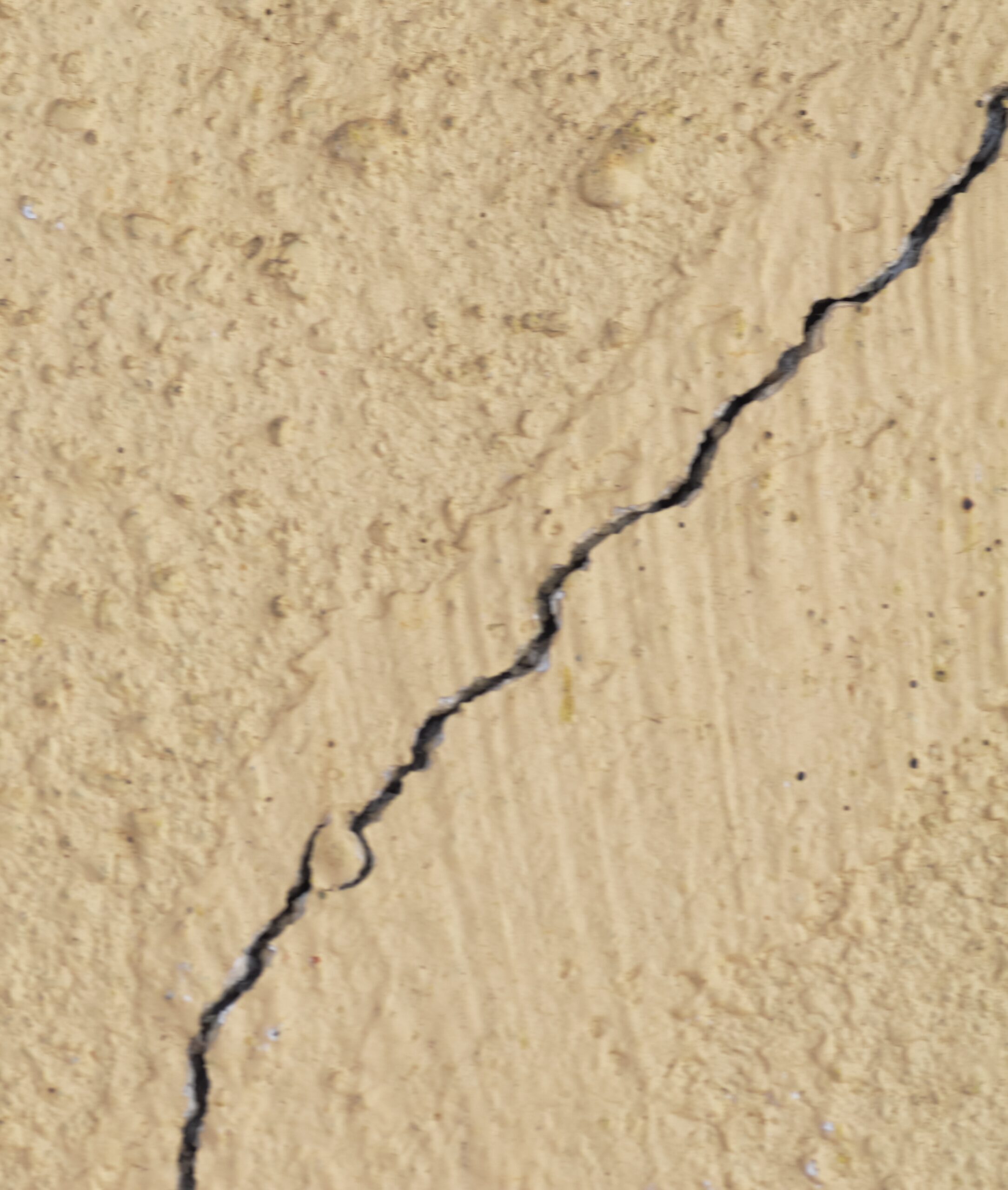 Stucco wall with a crack in it.